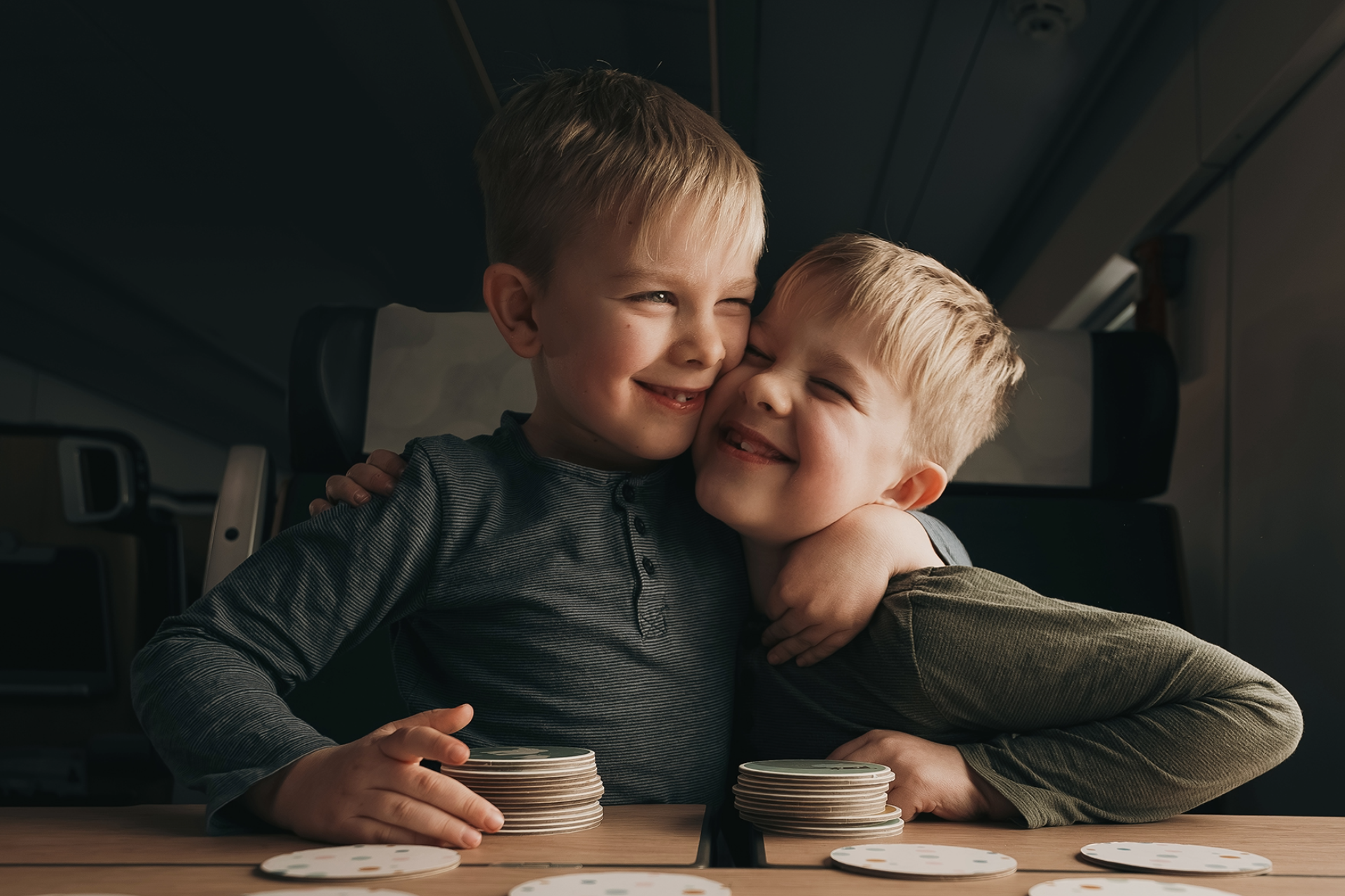 Two boys hugging eachother onboard the train, they are twins.